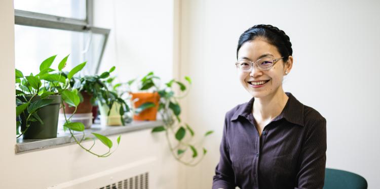 伊·雅典娜·任坐在她的书桌前。