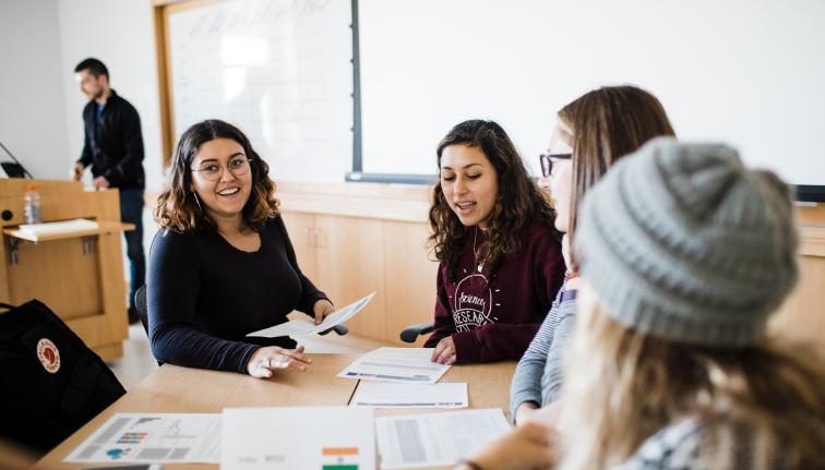 A group of five students working collaboratively in a group during class