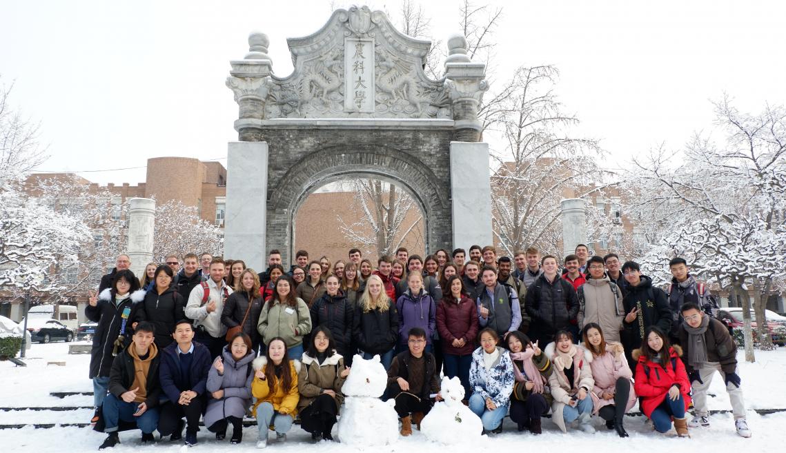 一群20多名学生在拱门前面的拱门占据汉字。